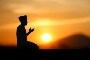 a silhouette of a man praying