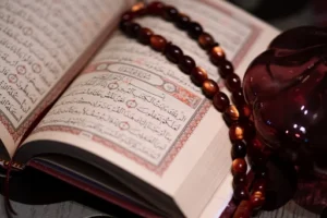 A book with a rosary and a glass figure, symbolizing faith and a Prayer for Healing.